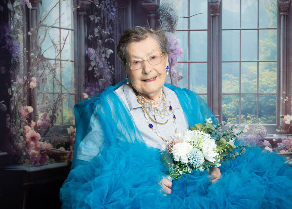 Resident smiling after her Glam Day makeover at Smithfield Lodge in Westlock while getting her photo taken